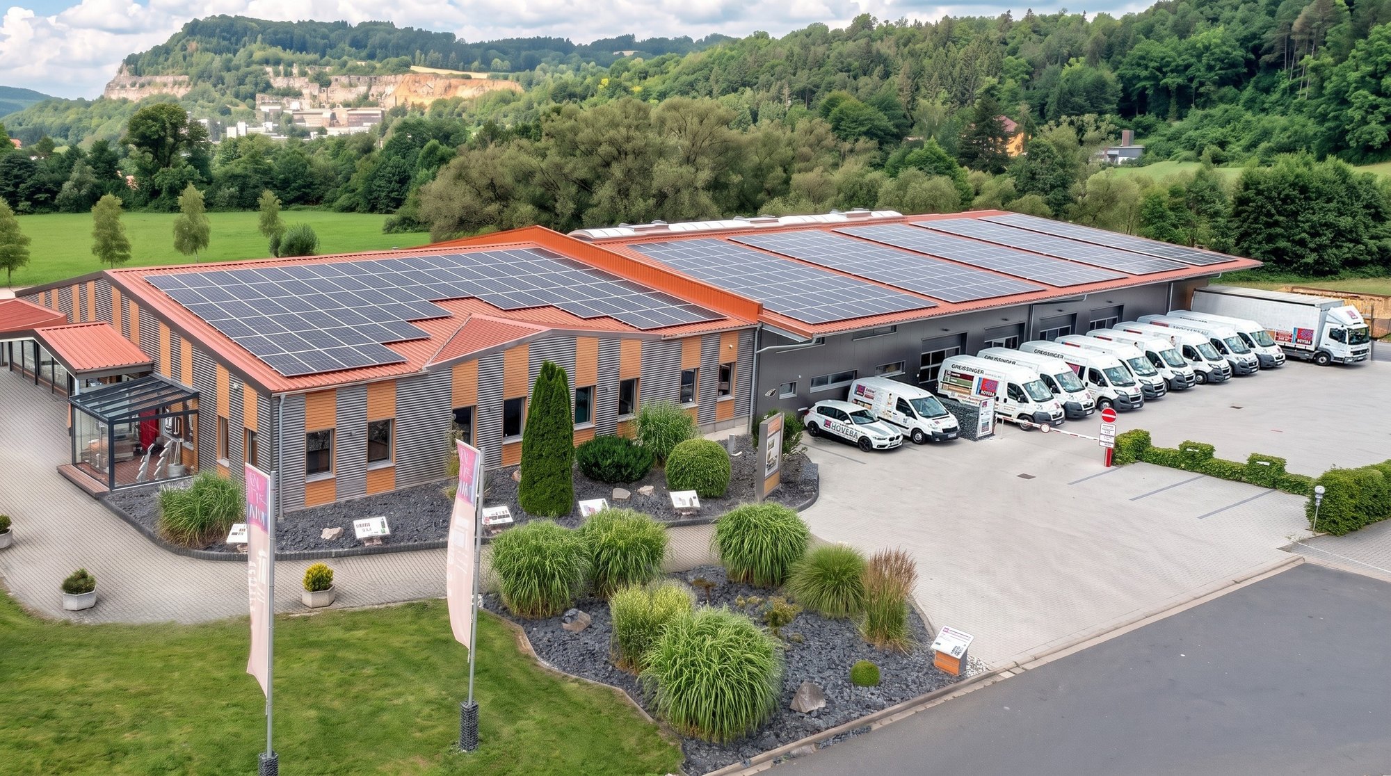Luftbild des HOVEBA-Firmengeländes in Weigendorf mit Ausstellung, Halle und Solaranlage auf den Dächern
