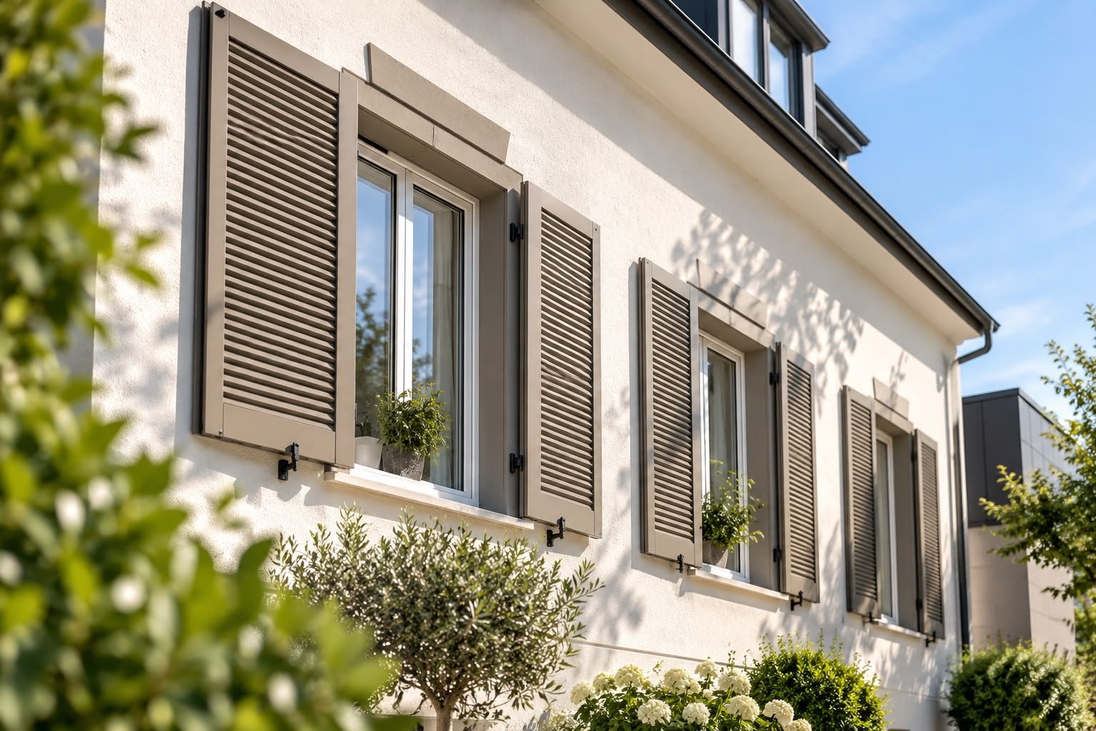 Taupefarbene Klappläden an heller Fassade