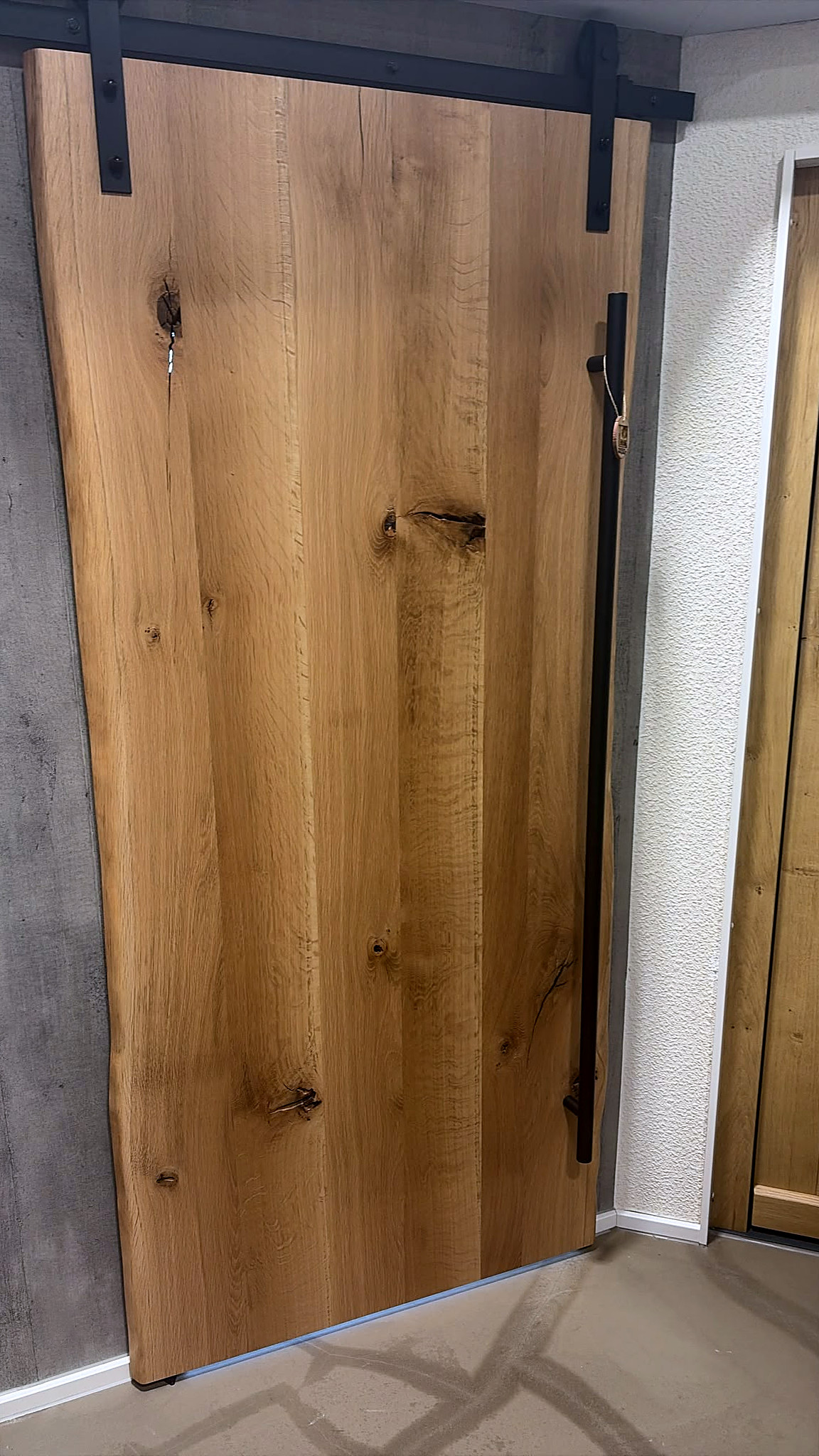Schiebetür aus Eiche mit schwarzer Laufschiene in der Ausstellung